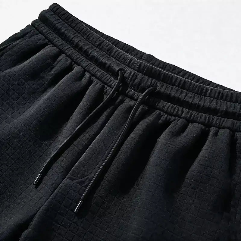 Close-up of black waffle cargo shorts with elasticated drawstring waist