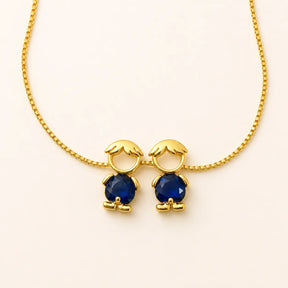 Gold-tone necklace with two boy figure pendants and blue stones