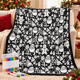 Black Christmas colouring blanket draped over a sofa before colouring, shown with the 24 fabric pens in their storage case