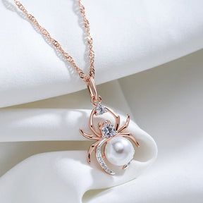 Pearl Weaver spider pendant necklace resting on white silk fabric